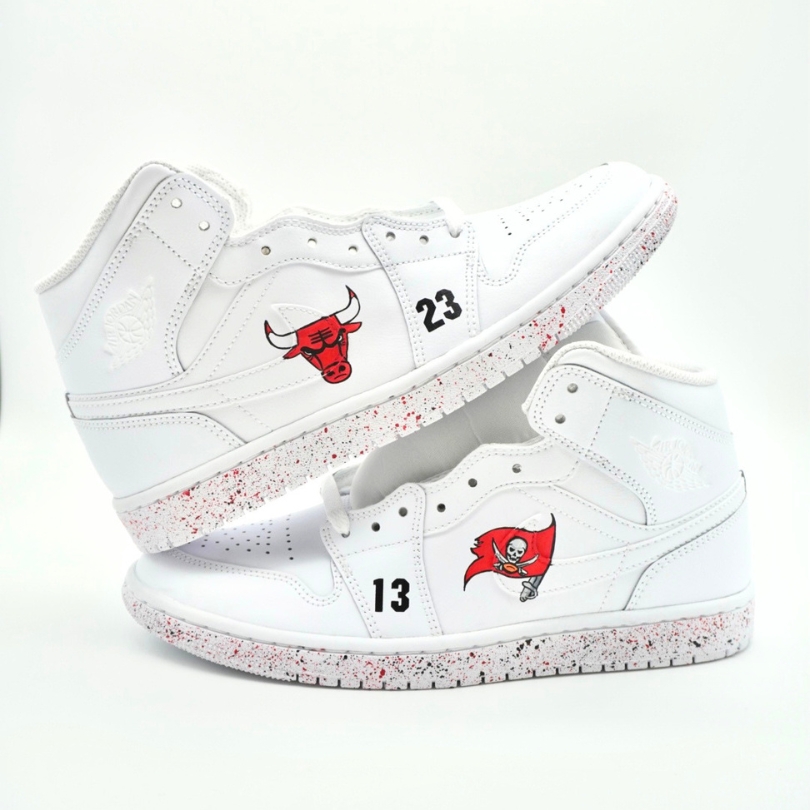 Paar weiße Nike Air Jordan 1 High Custom Sneaker mit Chicago Bulls Logo Nummer 23 und Tampa Bay Buccaneers Logo Nummer 13, rote Farbspritzer auf den Sohlen