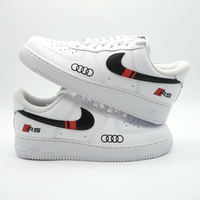 Weiße Sneakers mit schwarzem und rotem Design sowie Audi-Logo auf der Seite.