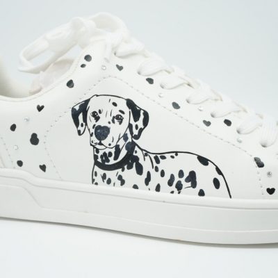 Nahaufnahme eines weißen Sneakers mit handgezeichnetem Dalmatiner-Porträt, schwarzen Pfotenflecken und kleinen schwarzen Herzen verteilt auf der Seitenfläche.