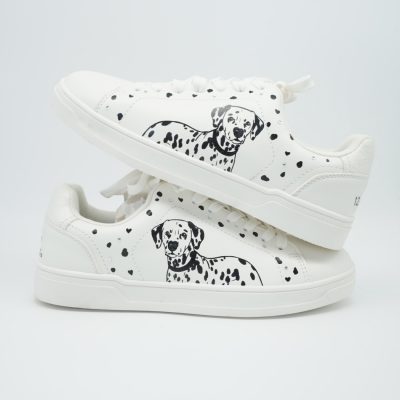Zwei gestapelte weiße Sneaker mit handgezeichnetem Dalmatiner-Motiv, schwarzen Flecken und feinen Herz-Akzenten auf beiden Seitenflächen.