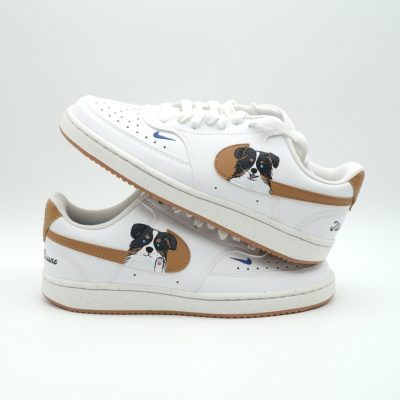 Zwei gestapelte weiße Nike Sneaker mit handgemalten Jack Russell Terrier Porträts, braunem Swoosh-Hintergrund und kleinen blauen Namens-Schriftzügen an der Ferse.
