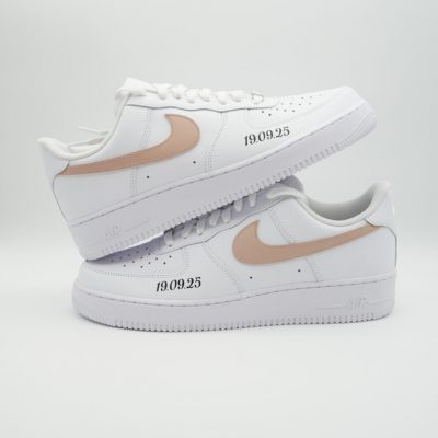 Zwei gestapelte weiße Nike Air Force 1 mit beigem Swoosh und feiner schwarzer Datumsangabe '19.09.25' an der Ferse im schlichten neutralen Hochzeitsdesign.