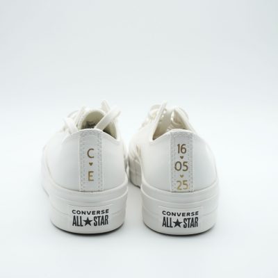 Rückansicht zweier weißer Converse All Star Plateau-Sneaker mit goldenen Initialen 'C' und 'E' sowie goldenem Datum '16.05.25' auf den weißen Fersenkappen.