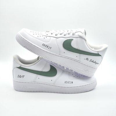 Zwei gestapelte weiße Nike Air Force 1 mit eukalyptus-grünem Swoosh, schwarzer Datumsangabe '06.09.25' und '12.12.24' sowie Schriftzügen 'Mr. Schultejans' und 'S&T'.