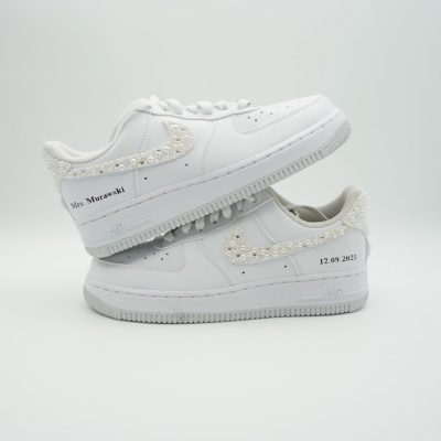 Zwei gestapelte weiße Nike Air Force 1 mit komplett perlenbesetztem Swoosh, kleinen Pünktchen und 'Mrs Murawski' Schriftzug sowie Datum '12.09.2025'.