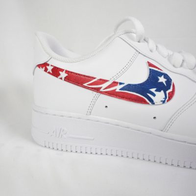 Weiße Sneakers mit einem roten und blauen Logo der New England Patriots auf der Seite.