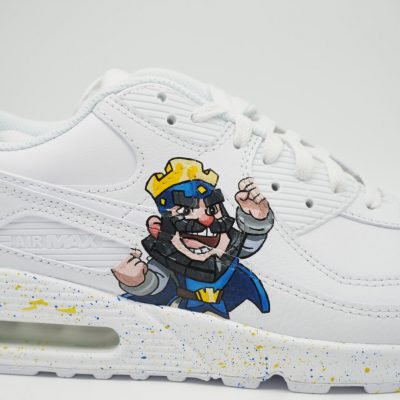 Weißer Nike Air Max Custom Sneaker mit Clash Royale Königs-Motiv, gemalte Figur mit Krone auf der Seite und gelb-blauen Farbspritzern auf der Sohle, Nahaufnahme