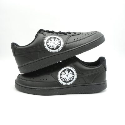 Paar schwarze Nike Sneaker mit Eintracht Frankfurt Adler-Logo in Weiß-Schwarz auf den Seiten beider Schuhe, gestapelte Präsentation vor neutralem Hintergrund