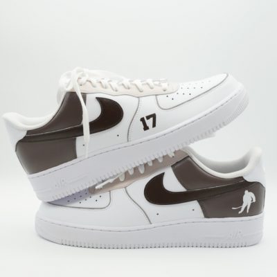 Paar weiße Nike Air Force 1 Custom Sneaker mit Eishockey-Motiv, brauner Swoosh Nummer 17 Eishockey-Spieler Silhouette auf der Ferse, gestapelte Präsentation