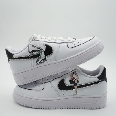 Paar weiße Nike Air Force 1 Custom Sneaker mit Eiskunstlauf-Design, schwarzer Swoosh mit Eiskunstläuferin auf beiden Schuhen, gestapelte Präsentation
