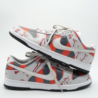 Paar Custom Sneaker mit Freddy Krueger Design, rot-grau-gestreiftes Muster mit Blutspritzern auf beiden Schuhen, gestapelte Präsentation vor hellem Hintergrund
