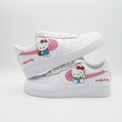 Zwei gestapelte weiße Nike Air Force 1 mit handgemalten Hello Kitty Motiven, rosa Swoosh-Akzent und rotem 'Hello Kitty' Schriftzug auf beiden Seitenflächen.