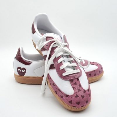 Paar weiße Adidas Samba Custom Sneaker mit dunkelroten Streifen und rosa Wildlederfläche, kleine Herz-Motive und Comic-Augen-Herz-Logo auf der Fersenkappe