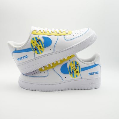 Paar weiße Nike Air Force 1 Custom Sneaker mit SGR Design, hellblau-gelbe Akzente Schriftzug Matthi und SGR-Logo als Banane, gestapelte Präsentation