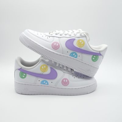 Paar weiße Nike Air Force 1 Custom Sneaker mit Pastell-Smiley-Faces in Rosa Gelb Grün und Lila, lila Swoosh-Element auf beiden Schuhen