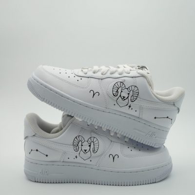 Paar weiße Nike Air Force 1 Custom Sneaker mit Sternzeichen-Motiv Widder, schwarze Linienzeichnungen mit Ramskopf Sternbild und Symbolen auf den Seiten