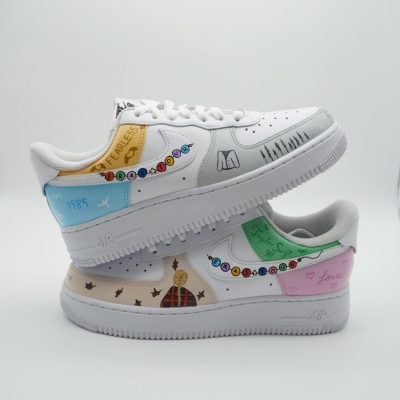 Paar weiße Nike Air Force 1 Custom Sneaker mit Taylor Swift Eras Tour Design, Freundschaftsarmband-Motive in Pastellfarben und verschiedene Album-Symbole, gestapelte Präsentation