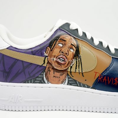 Custom Sneaker mit handgemaltem Travis Scott Portrait, lila-beige-blaue Farbgebung und Schriftzug auf der Außenseite, seitliche Nahaufnahme vor neutralem Hintergrund