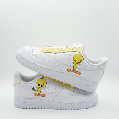 Paar weiße Nike Air Force 1 Custom Sneaker mit handgemaltem Tweety-Motiv und gelben Akzenten, gestapelte Seitenansicht beider Schuhe vor neutralem Hintergrund