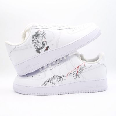 Paar weiße Nike Air Force 1 Custom Sneaker mit dezenten Streetstyle-Linienzeichnungen, Schlangen- und Hand-Motive in Schwarz mit roten Akzenten auf den Seiten