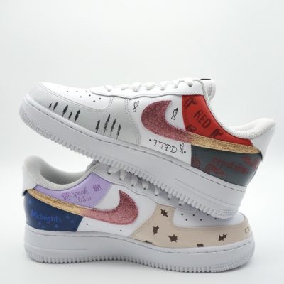 Zwei Paar Nike Air Force 1 Sneakers mit unterschiedlichen Designs und Farben übereinander gestapelt.