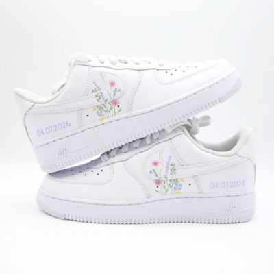 Paar weiße Nike Air Force 1 Custom Sneaker Modell Wild Blossom mit handgemalten zarten Wildblumen-Motiven auf den Swoosh-Elementen und Hochzeitsdatum 04.07.2026