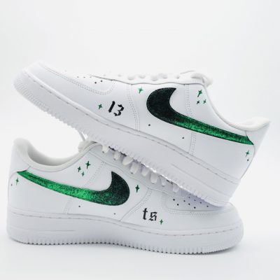 Weißer Sneaker mit grünen Glitzerakzenten und der Zahl 13 auf der Seite.