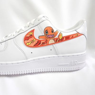 Weißer Nike Air Force 1 Sneaker mit einem Pokémon-Motiv von Charmander auf der Seite.