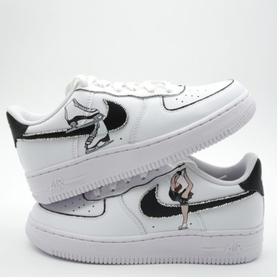 Weißes Nike Air Force 1 Sneaker Paar mit schwarz-weißen grafischen Designs auf der Seite.
