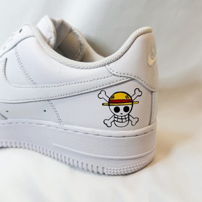 Weißer Nike Air Force 1 Sneaker mit einem Totenkopf-Logo auf der Ferse.