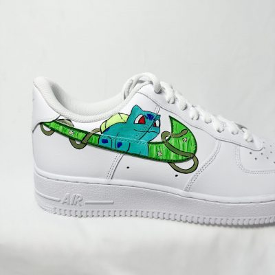 Weißer Sneaker mit einem bunten, handgemalten Design eines grünen Chamäleons und einer blauen Kreatur.