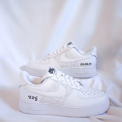 Weiße Nike Air Force 1 Sneakers mit Strassverzierungen und personalisierten Initialen.